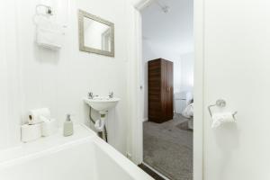 bagno bianco con lavandino e specchio di Whitechapel en-suite beds to stay a Londra