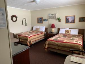 um quarto de hotel com duas camas e uma cadeira em carrollmotel and cottages em Twin Mountain