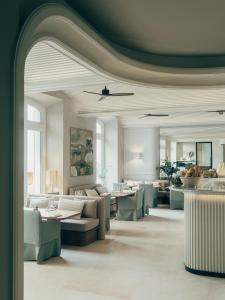 a lobby with couches and tables in a room at Hôtel & Spa Belle Plage in Cannes