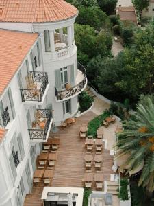 an aerial view of a building with chairs and tables at Hôtel & Spa Belle Plage in Cannes