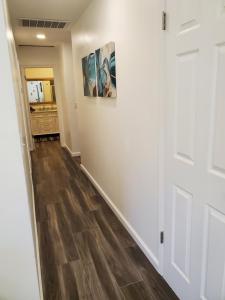 un pasillo con paredes blancas y suelo de madera en Amazing Oasis 3 in Clovis 4 Bedrooms, en Clovis