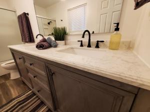 a bathroom counter with a sink and a mirror at Amazing Oasis 3 in Clovis 4 Bedrooms in Clovis
