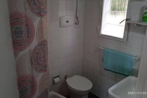 a bathroom with a toilet and a shower curtain at Casa en la Rambla in Colonia del Sacramento