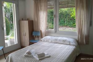 - une chambre avec un lit et 2 serviettes dans l'établissement Casa en la Rambla, à Colonia del Sacramento