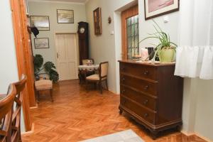 a hallway with a dresser and a dining room at Apartman Woolf in Senta