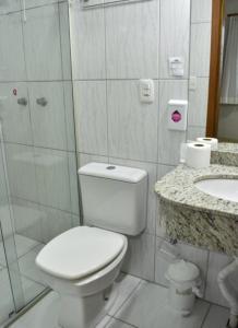 La salle de bains est pourvue de toilettes, d'une douche et d'un lavabo. dans l'établissement Hotel Monet, à Erechim