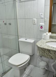 a bathroom with a toilet and a shower and a sink at Hotel Monet in Erechim +19 photos