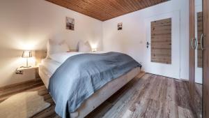 um quarto com uma cama com um cobertor azul em Haus Hohenwiesen em Lenggries