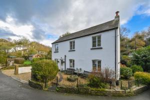 a white house on the side of a street at Briardene Cottage - A Superb Bijou Retreat with Jacuzzi near an Excellent Village Pub in Yelverton