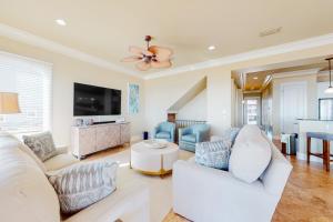 Una sala de estar con muebles blancos y un ventilador de techo. en Casa Del Mar, en Gulf Shores