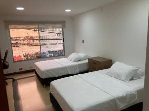 ein Schlafzimmer mit 2 Betten und einem Wandgemälde in der Unterkunft Departamento Cerca a la Terminal del Sur MAG201 in Medellín