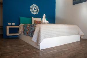 a bedroom with a large bed with a blue wall at Azul 36 Hotel in Bacalar