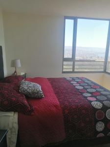 - une chambre avec un lit et une grande fenêtre dans l'établissement Altavistamar, à Viña del Mar
