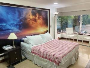 1 dormitorio con 1 cama y una gran pintura en la pared en Departamento Cerca a la Terminal del Sur MAG201, en Medellín