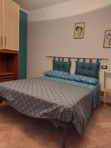 1 dormitorio con 1 cama grande con almohadas azules en La casa del dog trekking, en Piglio