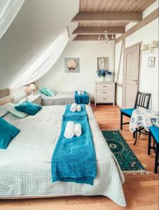 a bedroom with two beds with blue sheets and towels at Villa Mila in Mikołajki