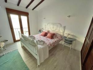 Casa con maravillosas vistas al mar في أليكانتي: غرفة نوم مع سرير أبيض مع وسائد وردية