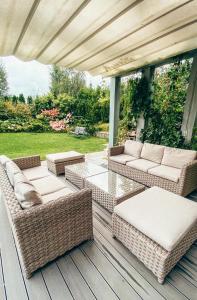 patio z wiklinowymi meblami na drewnianym tarasie w obiekcie Villa Mila w mieście Mikołajki