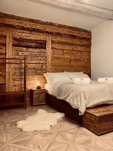 sypialnia z dużym łóżkiem i drewnianą ścianą w obiekcie Marzeniówka w mieście Lutowiska