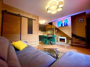 a living room with a couch and a tv at Duplex rénové - 3 CHAMBRES 8 PERS dernier étage in Les Orres