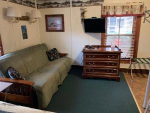 uma sala de estar com um sofá e uma mesa em carrollmotel and cottages em Twin Mountain