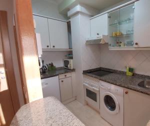 een keuken met een wasmachine en een wastafel bij Apartamento Samil Primera Línea de Playa 2M in Vigo