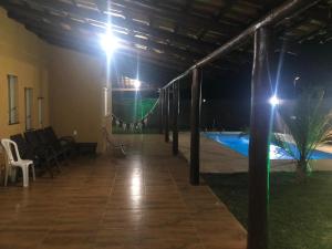 a pavilion with a pool at night with lights at Rancho Casa com piscina próxima ao Rio São Francisco- Não fica no centro de Três Marias, e sim no bairro Beira Rio às margens do Rio in Três Marias