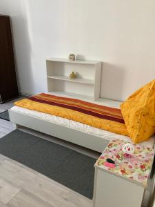 a bedroom with a bed and a table at Strand Apartament in Sibiu