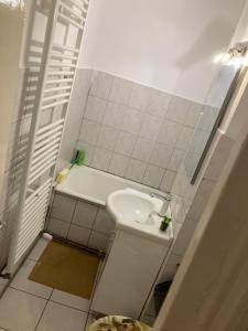 a small bathroom with a sink and a tub at Strand Apartament in Sibiu