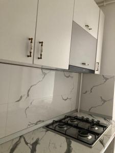 a stove top in a kitchen with white cabinets at Strand Apartament in Sibiu