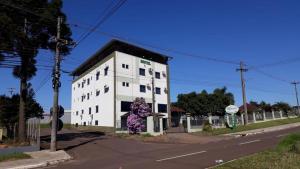 un edificio blanco en la esquina de una calle en Hotel Monet en Erechim