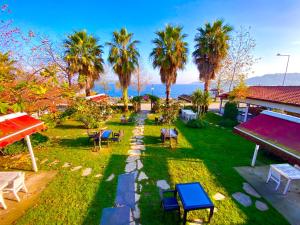 a park with chairs and palm trees and the ocean at Peri Boutique Hotel in Sapanca