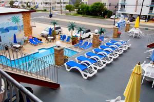 a group of lounge chairs and umbrellas next to a pool at Florentine Family Motel in North Wildwood