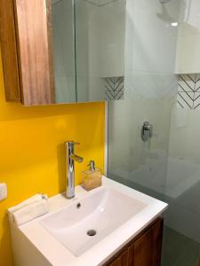 W łazience znajduje się biała umywalka i prysznic. w obiekcie Ulivin Apartaestudios Manizales w mieście Manizales