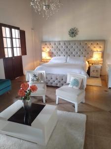 Hotel Colonial Andino - Parque principal de Pitalito في بيتاليتو: غرفة نوم كبيرة بها سريرين و مزهرية بها زهور