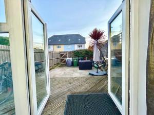 een kamer met glazen schuifdeuren en uitzicht op een patio bij Sensational 3-Bed Home Near Bluewater in Kent