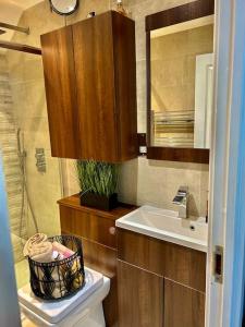 a bathroom with a sink and a toilet and a mirror at Sensational 3-Bed Home Near Bluewater in Kent