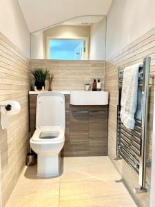 een badkamer met een wit toilet en een wastafel bij Sensational 3-Bed Home Near Bluewater in Kent