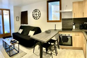 een woonkamer met een bank en een tafel in een keuken bij Duplex au coeur du village in Les Mées