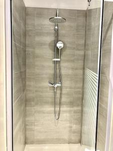 een douche met een glazen deur in de badkamer bij Duplex au coeur du village in Les Mées