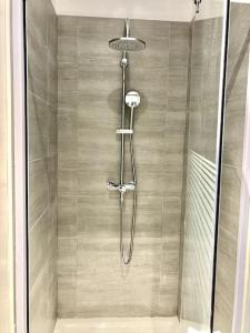 a shower with a glass door in a bathroom at Duplex au coeur du village in Les Mées