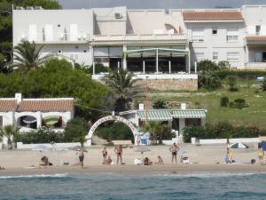 a group of people on a beach near the water at Hotel Llorca in Platja de l’Almadrava