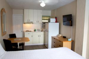 a small kitchen with a white refrigerator and a table at Florentine Family Motel in North Wildwood