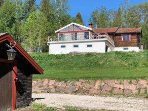 uma casa no topo de uma colina relvada em Charmig stuga med panoramautsikt över sjön Siljan. em Rättvik