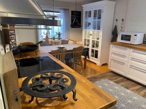 uma cozinha e sala de estar com uma mesa e um fogão em Charmig stuga med panoramautsikt över sjön Siljan. em Rättvik