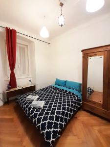1 dormitorio con 1 cama con edredón blanco y negro en Casa Antica - Historical apartment in old city center, en Trieste