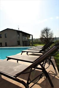 - une rangée de tables de pique-nique à côté de la piscine dans l'établissement Appartamento Franciacorta, à Cazzago San Martino
