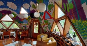 a dining room with a table and chairs and a colorful ceiling at Tierra de Domos in Villarrica