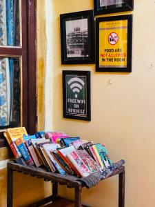 uma pilha de livros num banco numa sala em Saffron Homestay em Jaisalmer