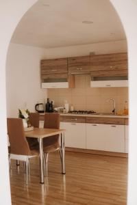 - une cuisine avec une table et des chaises en bois dans l'établissement Cozy 2-Bedroom Boho-Themed Home, à Caransebeş